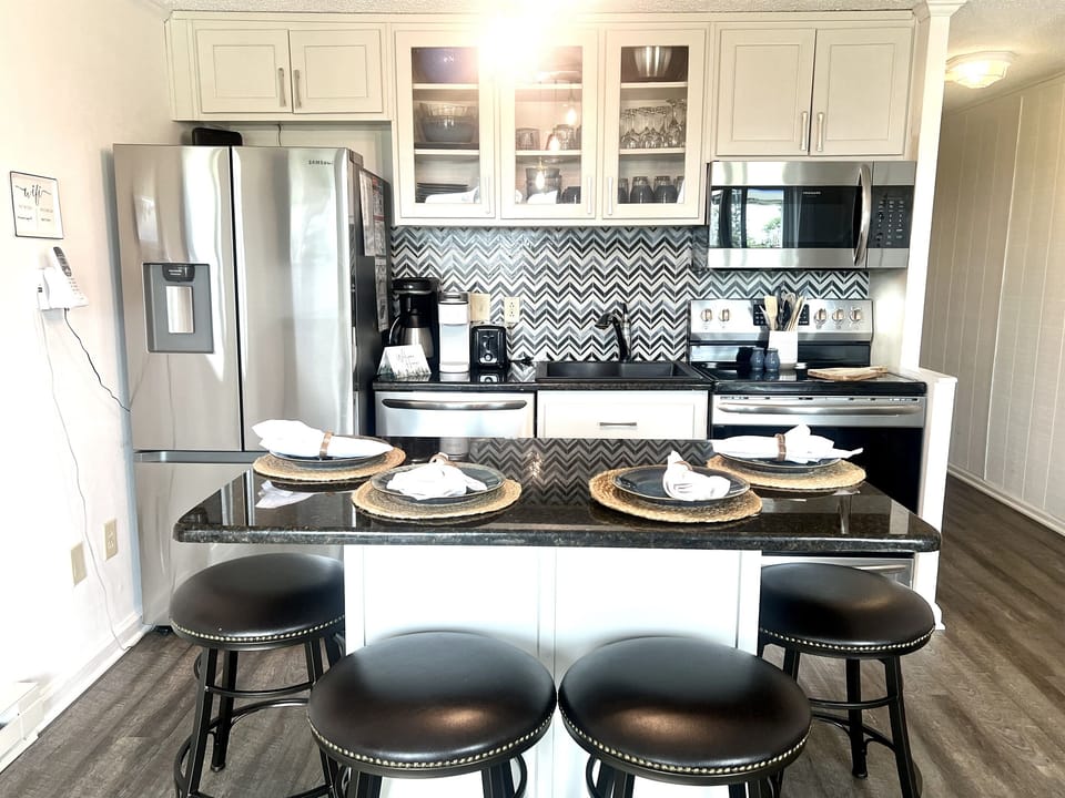 Renovated kitchen with stainless steel appliances and seating for four