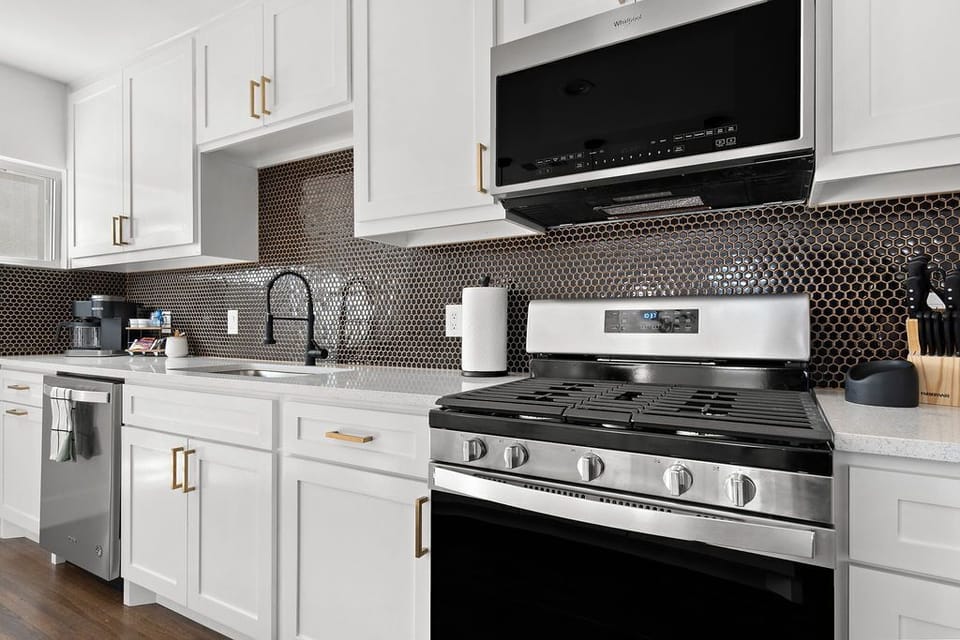 Fully stocked kitchen includes gas stove, pots, pans and baking dishes.