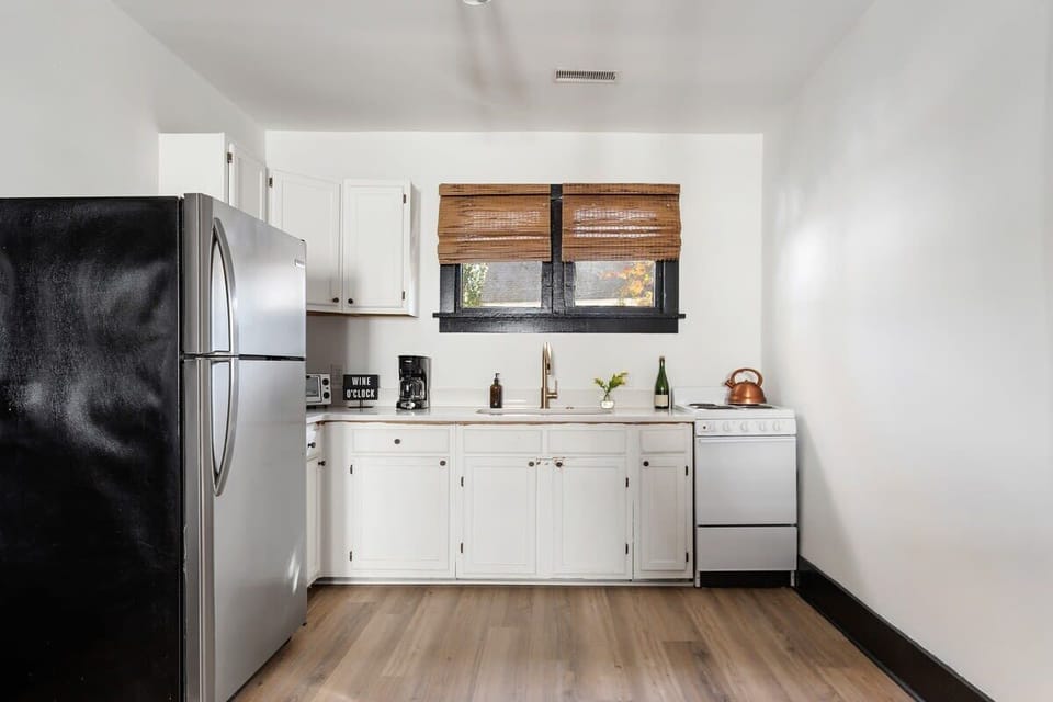Kitchen stocked with pots, pans, dishware, and all the basic things you may need to cook.