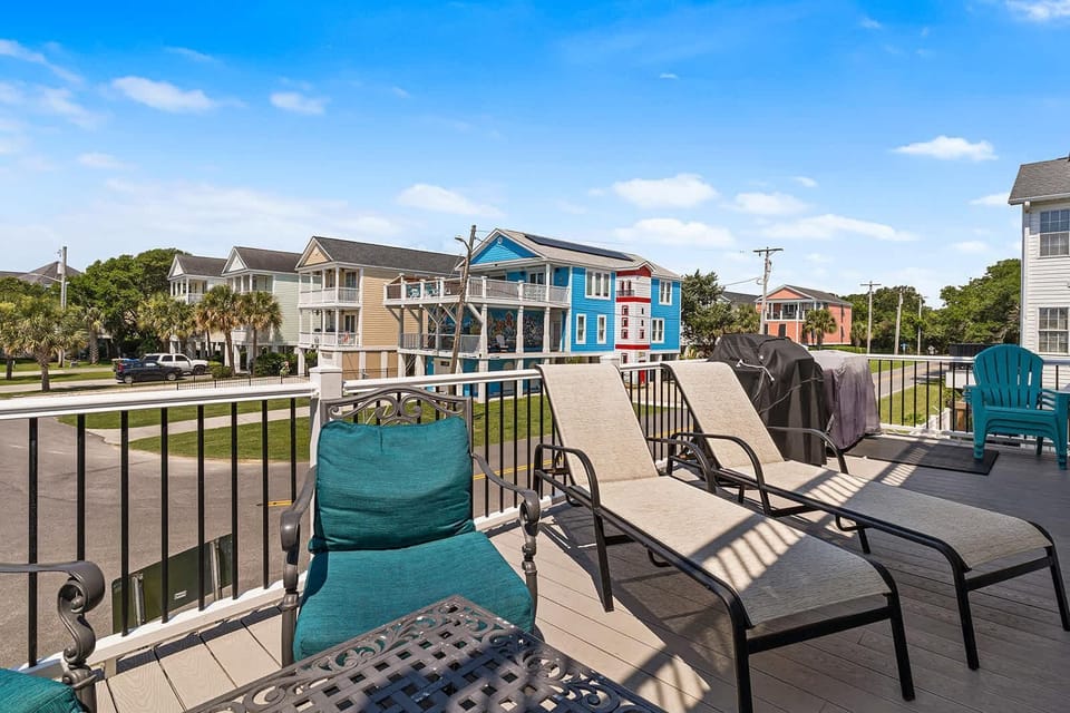Sunny balcony with comfortable seating and vibrant neighborhood views