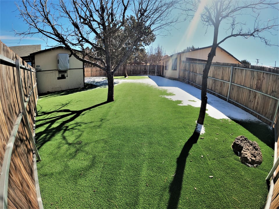 fenced in yard for kids to play with turf