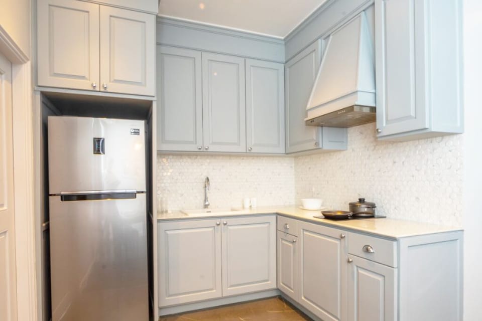 Kitchennette with a big firdge and a freezer top 