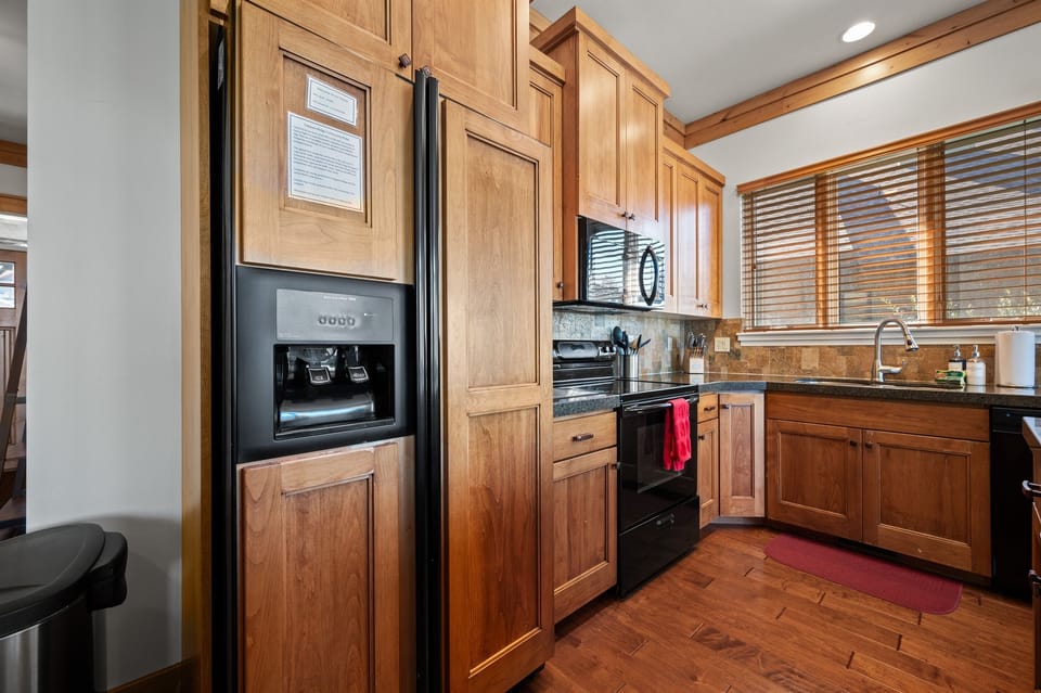 With its modern lighting, windows, quartz countertops, and stunning backsplash, the kitchen makes preparing dinner a truly enjoyable experience.