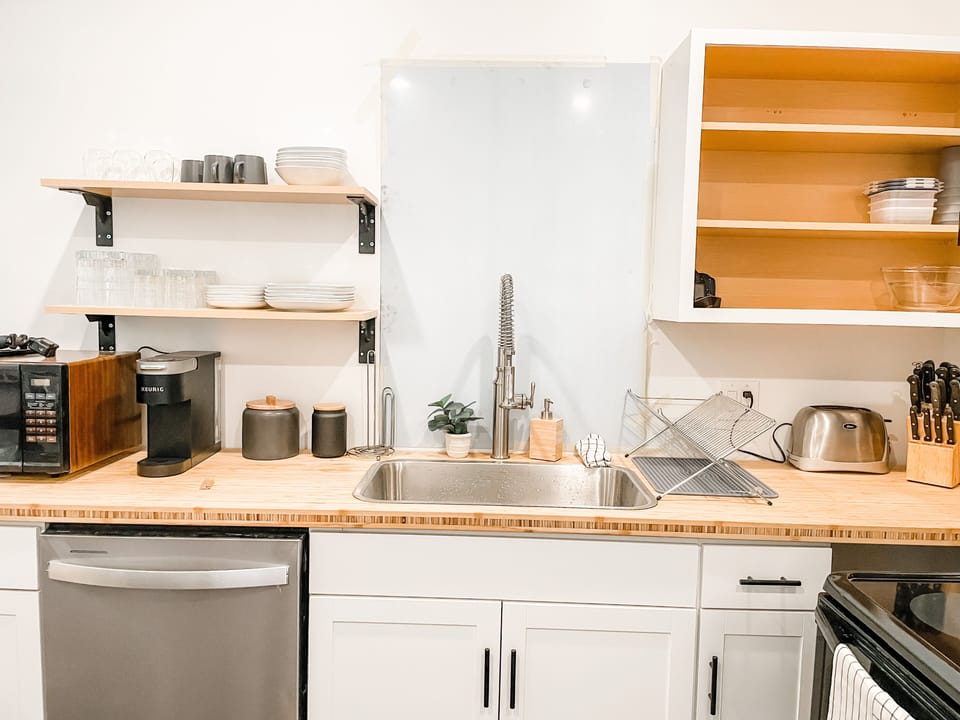 Natural Butcherblock Countertops, Kohler spray faucet, nice Calaphon pots & pans
