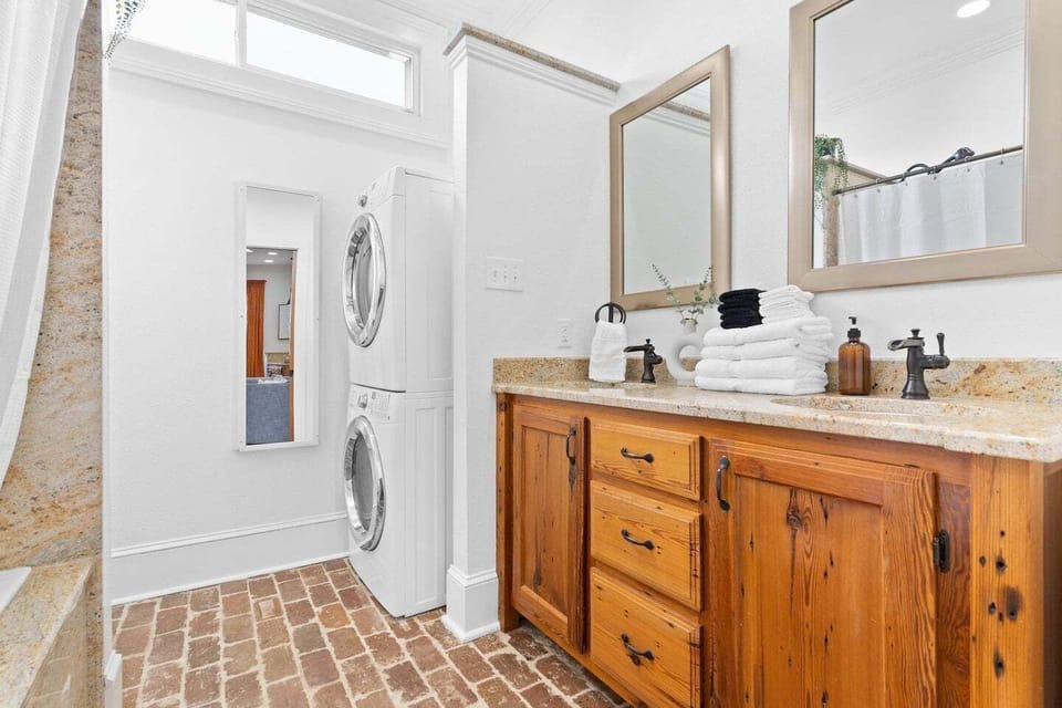 Clean bathroom w/ warm wood vanity & ample counter space for getting ready.
