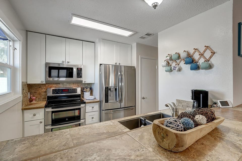 Cook your favorite meals in this bright, fully-equipped kitchen featuring stainless steel appliances and granite countertops.