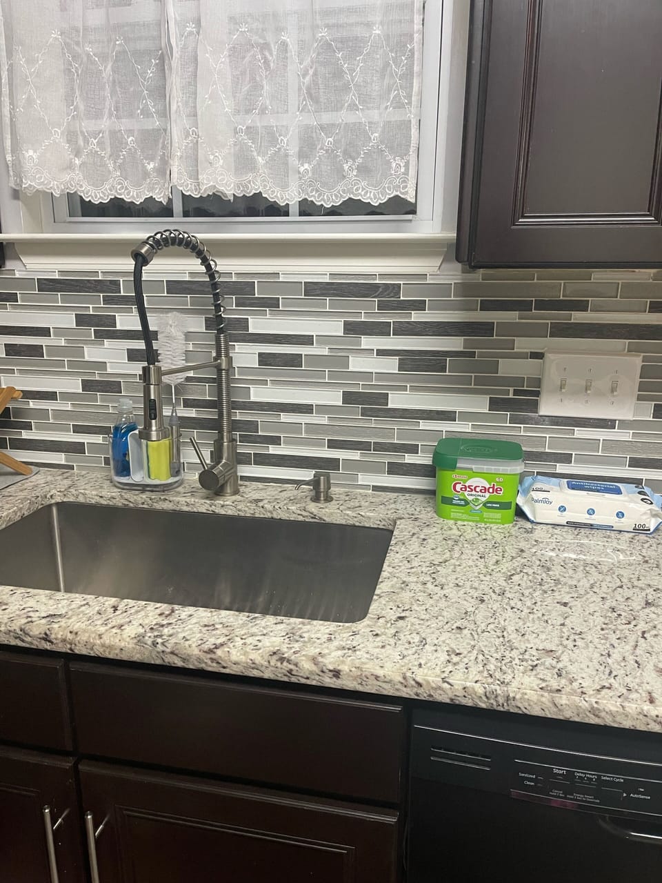 Large modern farmhouse sink in stainless steel, granite counter tops.