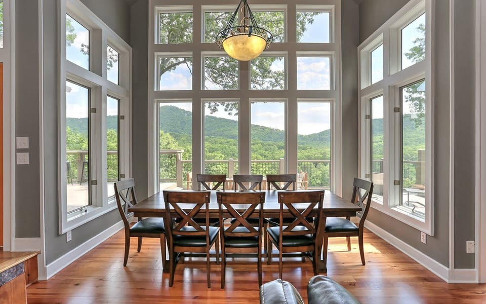 Dining Table Surrounded by Large Windows and Mountain Views