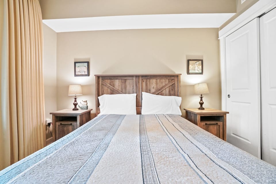 Your cozy bedroom features rustic wooden headboard, bedside lamps, and peaceful neutral tones for restful nights.
