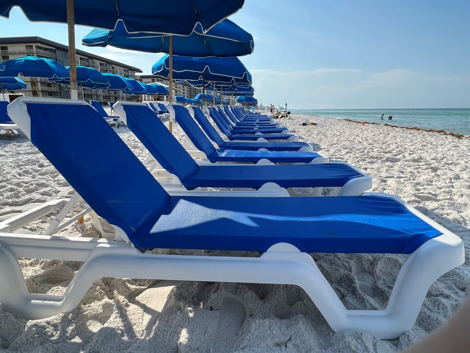 Private beachfront offers pristine white sand and turquoise waters with complimentary blue loungers and umbrellas for your perfect beach day.