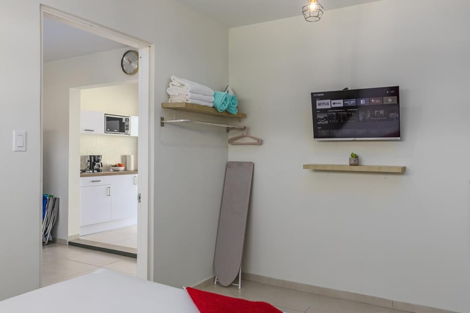 A bedroom with TV, an air-conditioning unit.