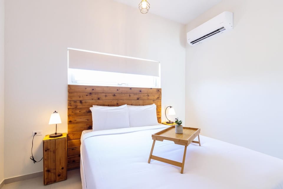 A queen size bedroom with a wooden headboard and comfortable bed frame and mattress perfect for couples.