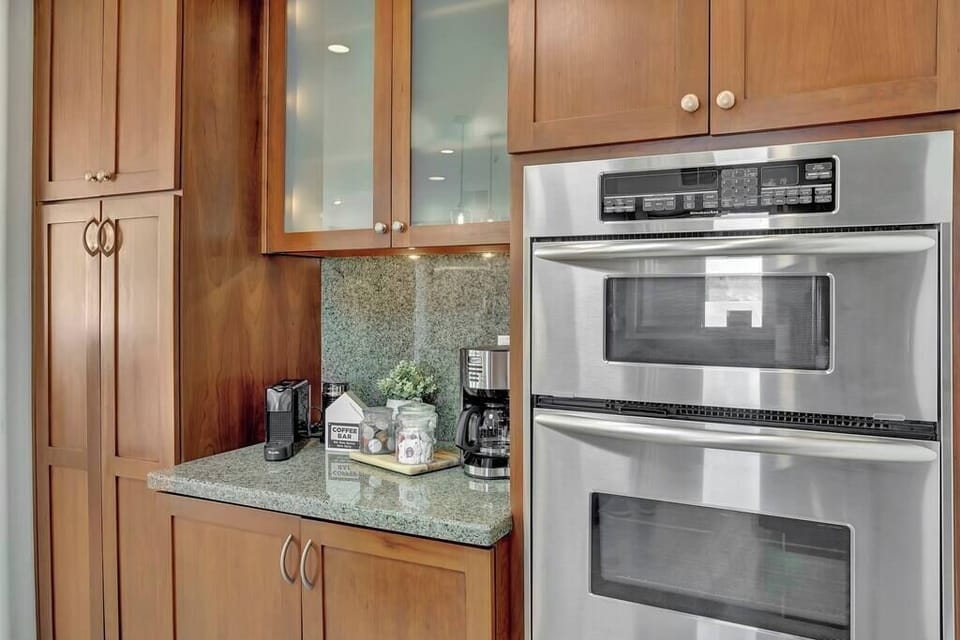 Modern kitchen corner with stainless steel double oven and coffee station