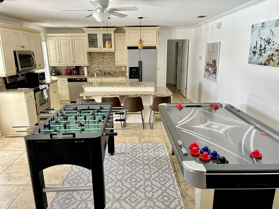 Your entertainment awaits in this stunning open-concept space where foosball and air hockey blend seamlessly with a gourmet kitchen for endless fun.