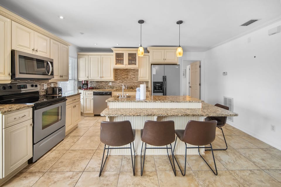 Your stunning granite island and sleek stainless appliances make cooking a joy in this fully equipped kitchen.