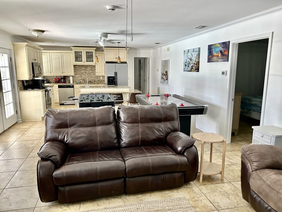 Relax in your spacious living area with plush leather seating, then challenge friends to air hockey while enjoying the open-concept kitchen nearby.