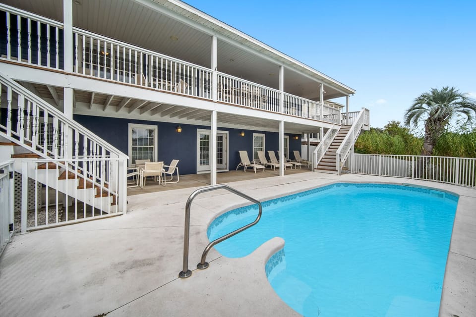 Two-story vacation home featuring a private swimming pool surrounded by spacious outdoor areas and tropical landscaping.