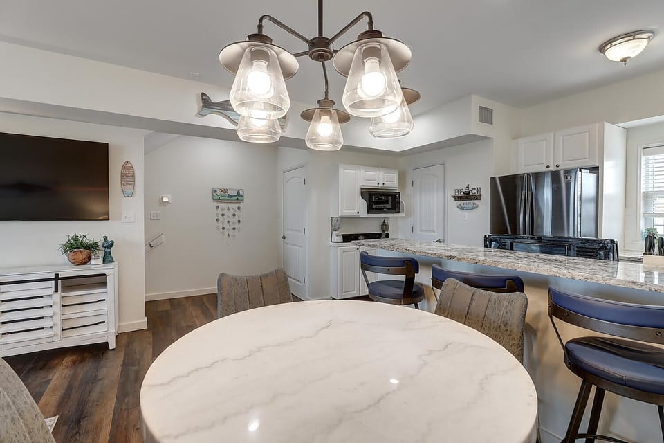 Gather around your elegant dining table or chat at the granite breakfast bar in this beautifully lit space with modern fixtures.