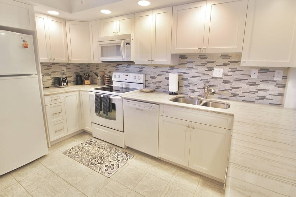 Beautiful shaker cabinets are filled with dishes, glasses, pots and pans, bakeware, utensils and more.