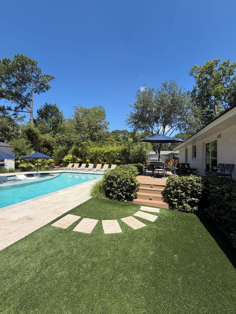 Backyard with walkway from pool deck to patio deck