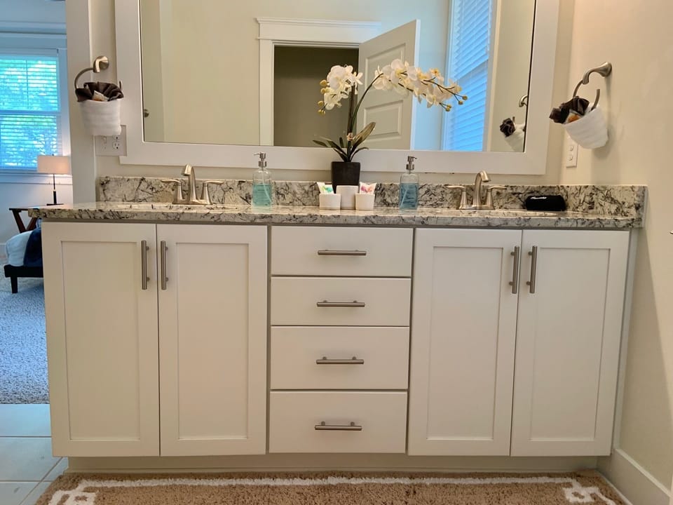 Primary bath w/double vanities, water closet, glass shower