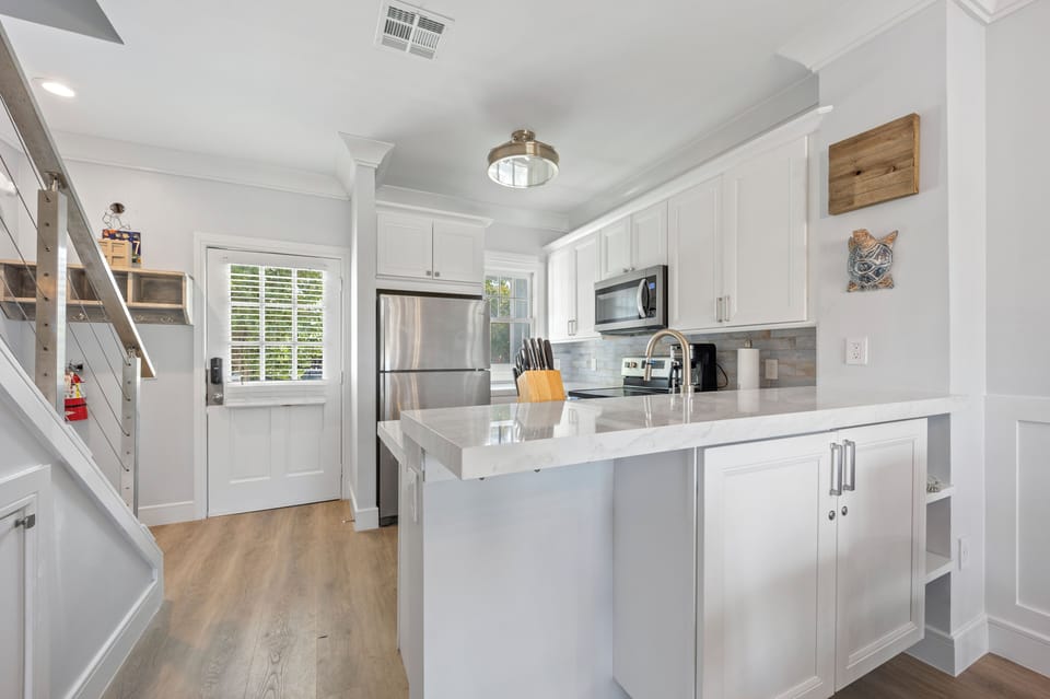 Full kitchen, Front door, and staircase to upstairs bedrooms 