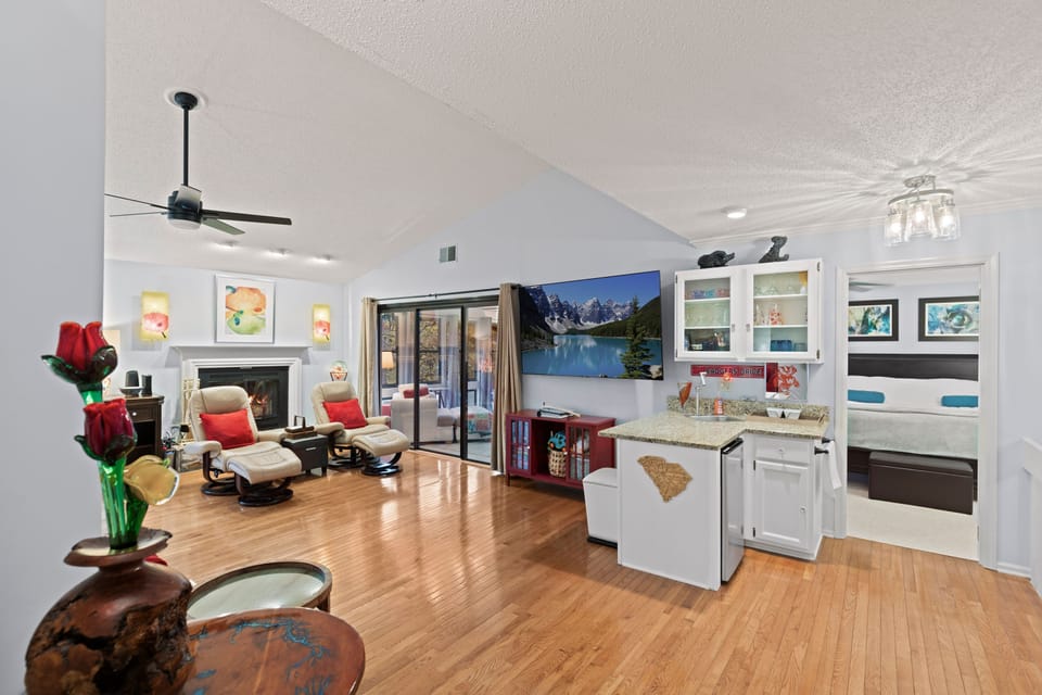 Living room: open concept, 85" TV, seating for everyone, wet bar, fireplace.