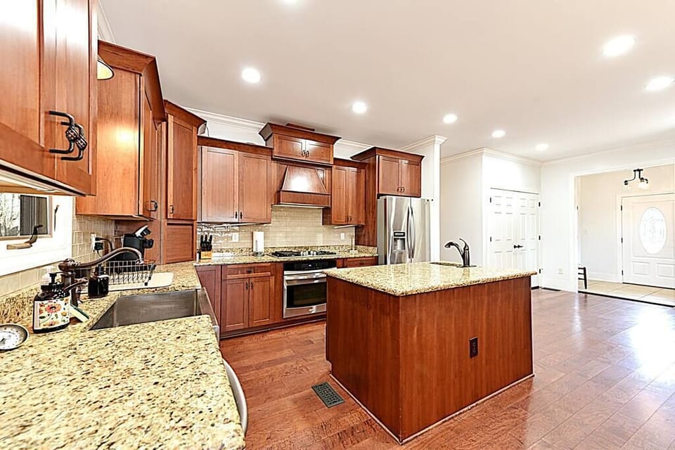 Custom kitchen with island, gas range, 2 sinks, and a ton of prep space.