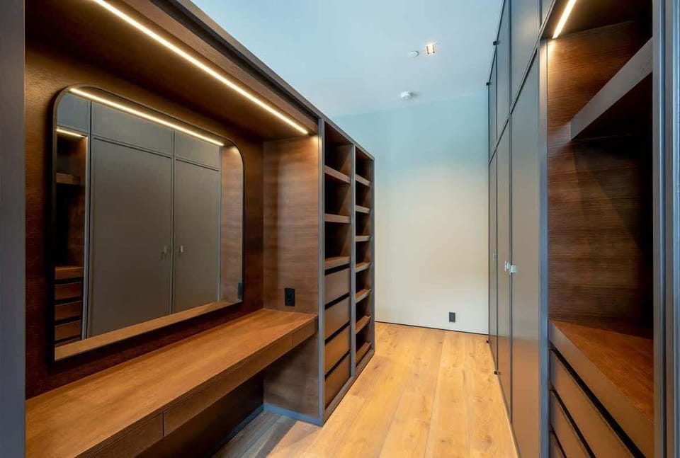 - Spacious walk-in closet with sleek wood cabinetry and lighting  
- Designed for organized storage and easy vacation living  
- Modern dressing area blending warmth and style  
