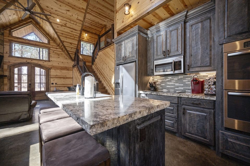 Large granite island with microwave, double oven, refrigerator