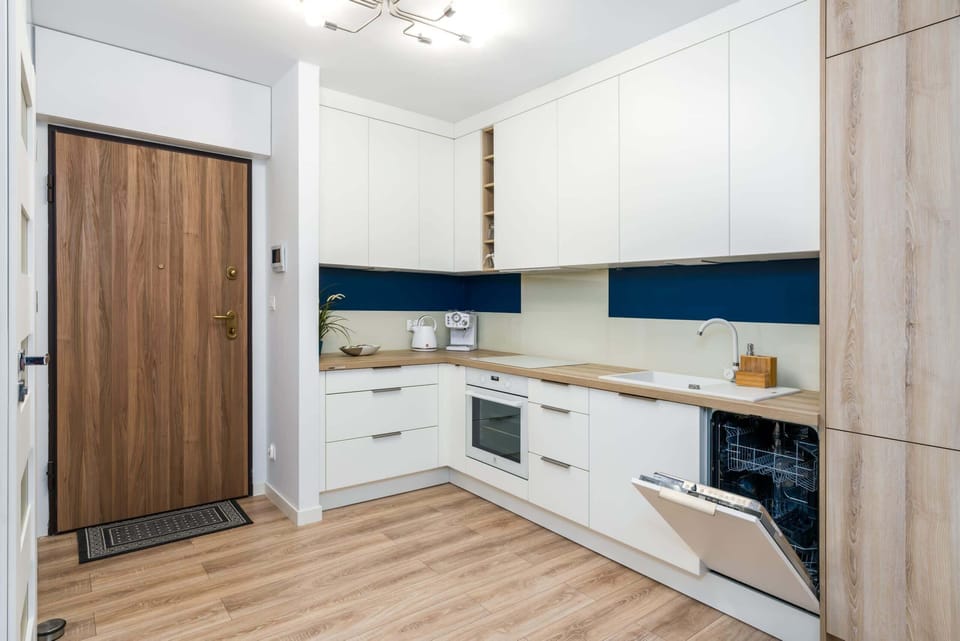 A modern kitchen corner featuring clean lines and a vibrant blue backsplash.