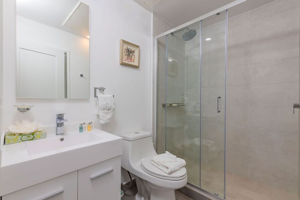 Fresh towels, modern fixtures, and a spacious glass-enclosed shower await you in your spotless private bathroom, where every detail is designed for your comfort and convenience.