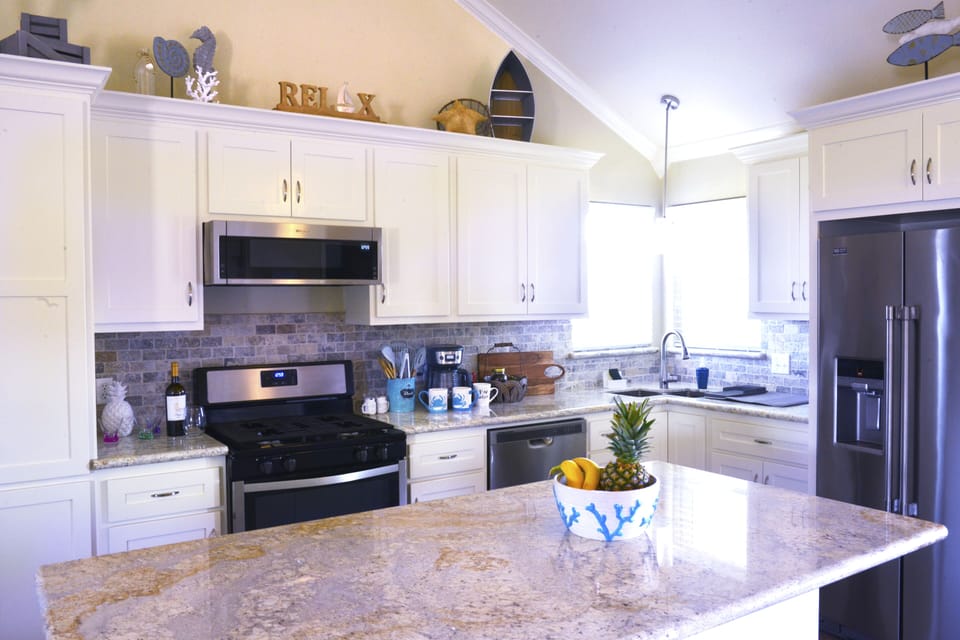 open bright kitchen with gas range and grante countertops and large island