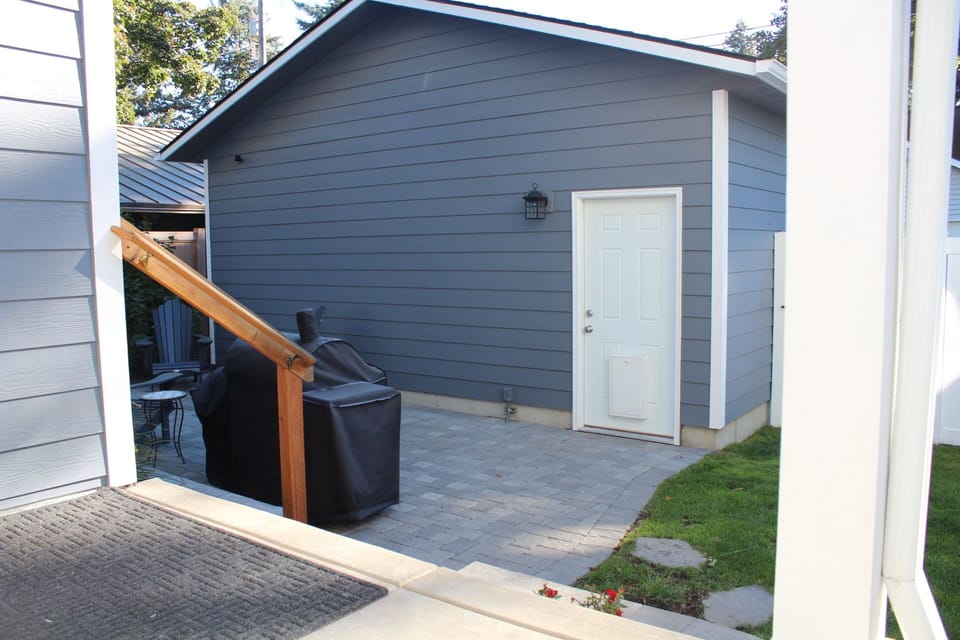 Backdoor landing overlooking patio and 2-car garage