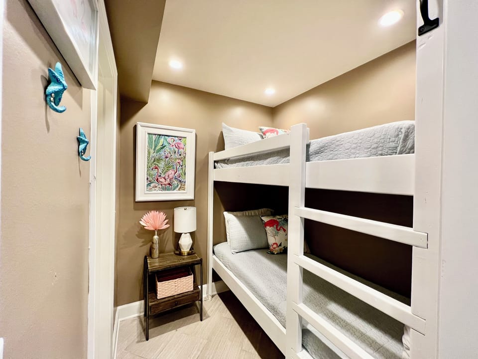 Your kids will love these cozy bunk beds with soft linens and charming tropical artwork creating the perfect space for sweet dreams.