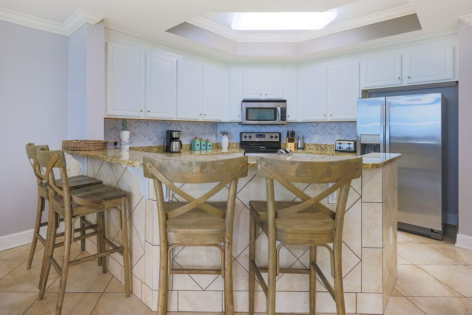 This kitchen features stainless appliances, granite countertops, and a cozy breakfast bar for a delightful cooking experience
