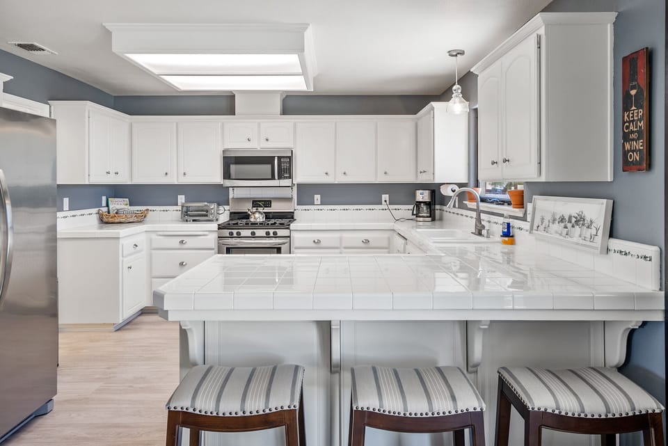 Full kitchen with bar seating, large clean countertops to serve