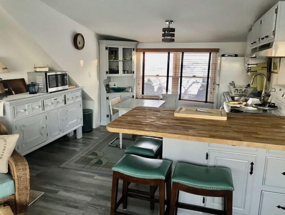 kitchen offers table and chairs as well as butcher block counter with stools.
