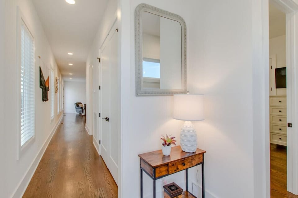 A wide bedroom with natural light, framed art, and layered bedding creates a comfortable retreat.