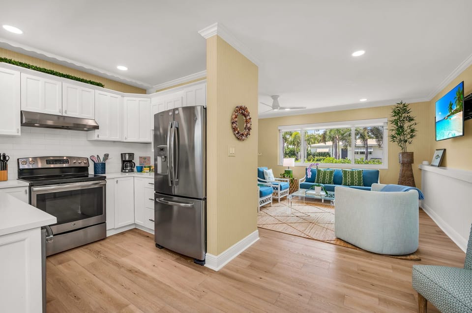 The luminous, fully-equipped kitchen serves as a culinary haven, perfect for post-beach gatherings or sunset cookouts. It's thoughtfully stocked with all the essentials for cooking, whether you're dining indoors or outdoors.