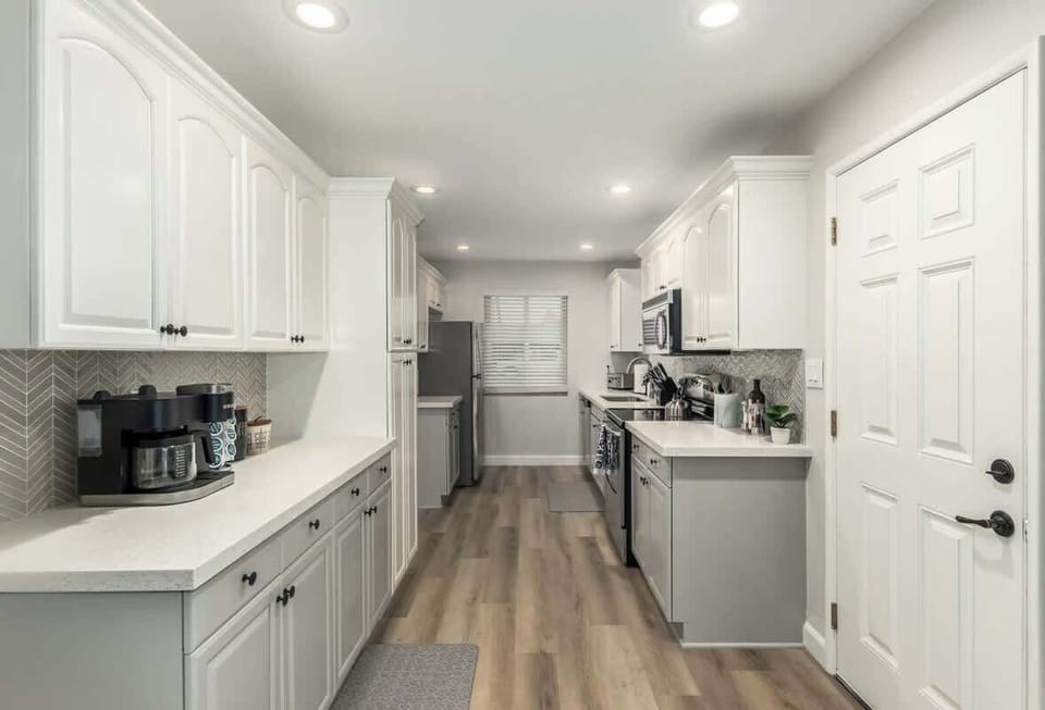 Stainless steel appliances and white shaker cabinets