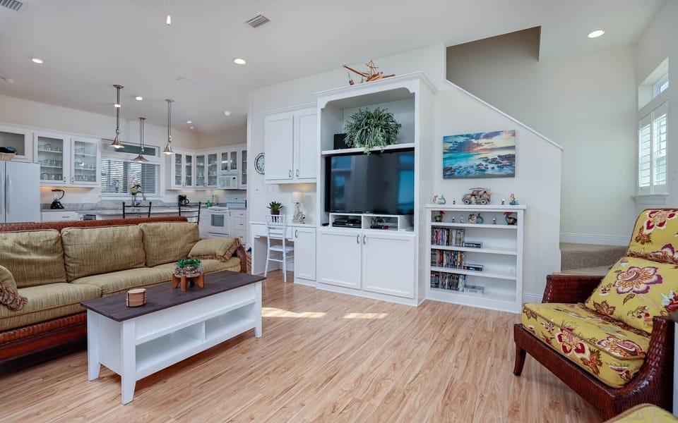 The living area features a large TV, comfortable seating, and an open layout that enhances relaxation and entertainment