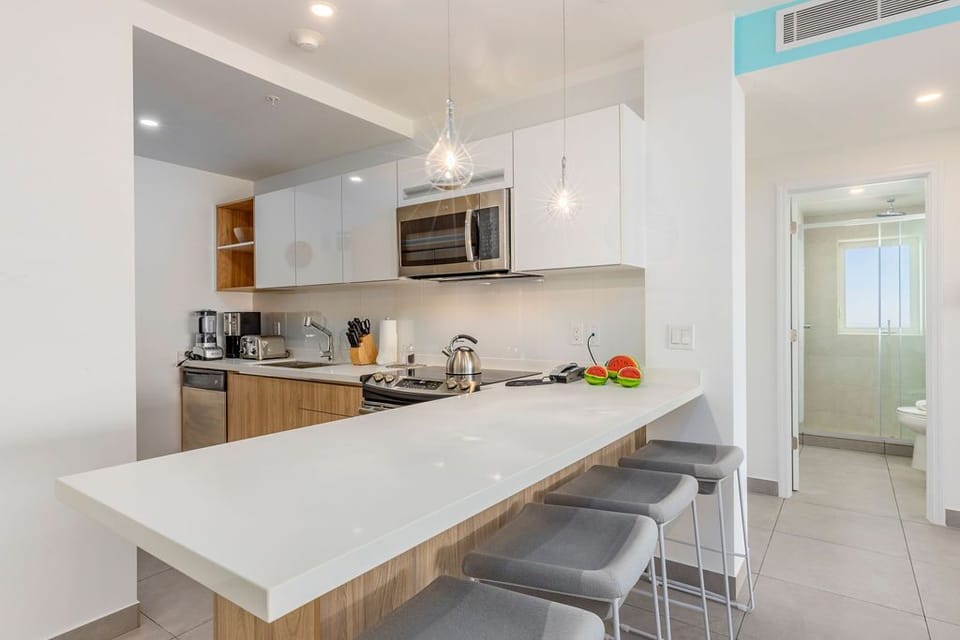 Your sleek, fully equipped kitchen awaits with modern appliances, a spacious breakfast bar, and all the tools you need to prepare meals in style and comfort.