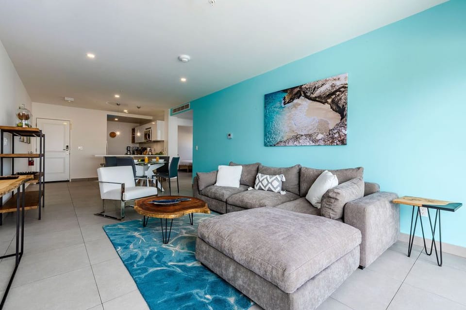 Sink into comfort on the plush sectional surrounded by ocean-inspired hues, with an open kitchen ready for your culinary adventures.