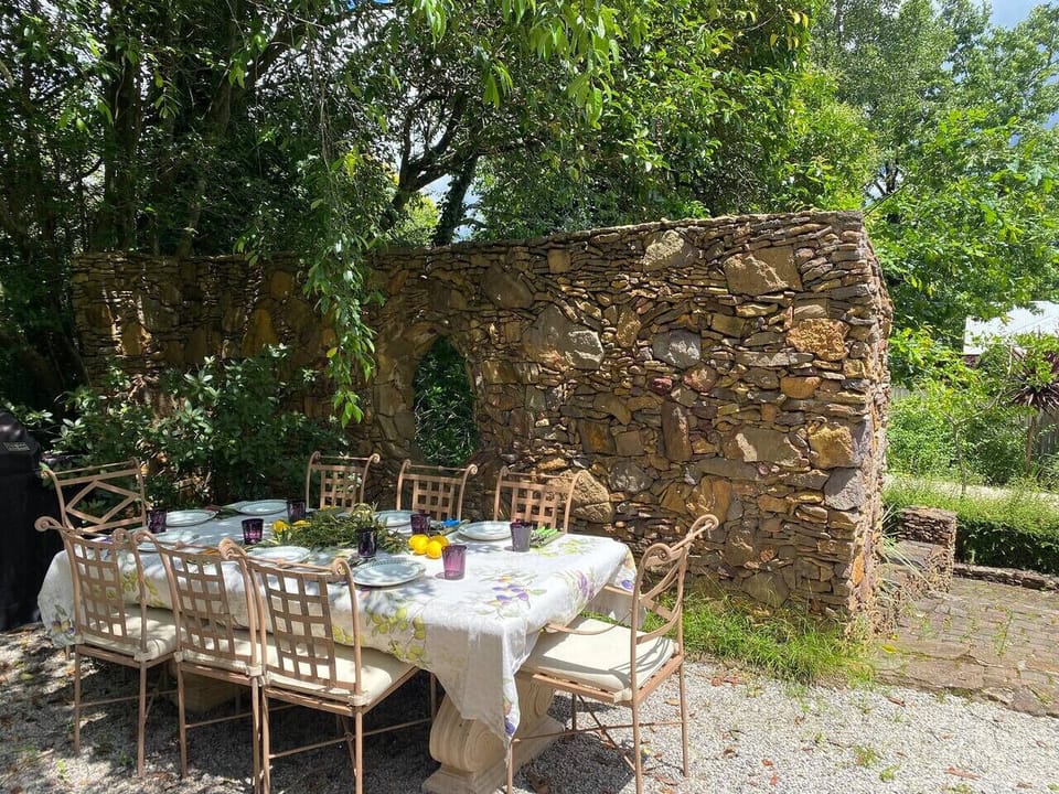 Outdoor dining beside the stone garden wall