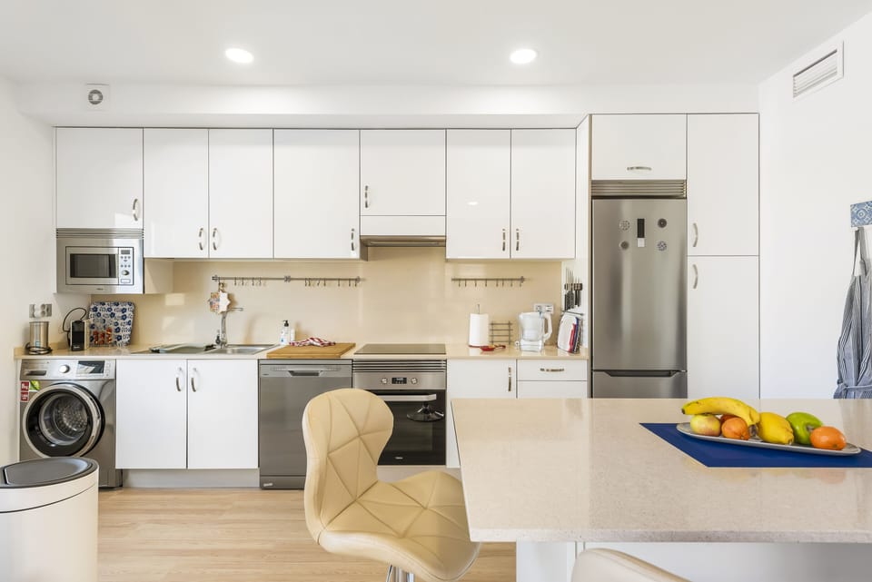 Full view of kitchen from washing machine to fridge/freezer.