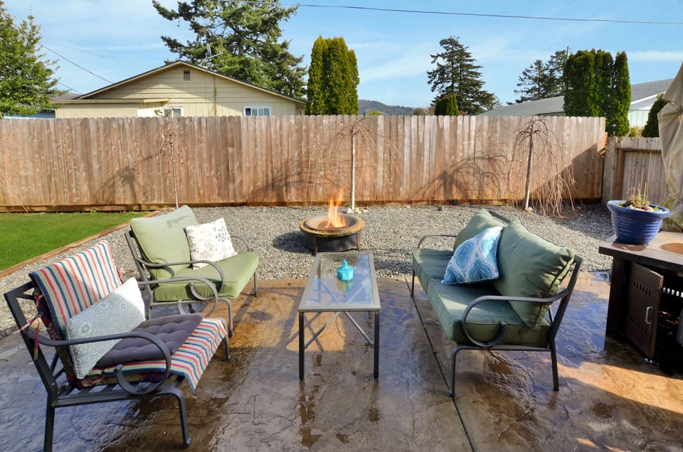Backyard sitting area with a wood fire pit and a gas fire pit table. 