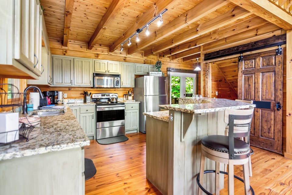 Spacious kitchen with stainless steel appliances, granite counters.