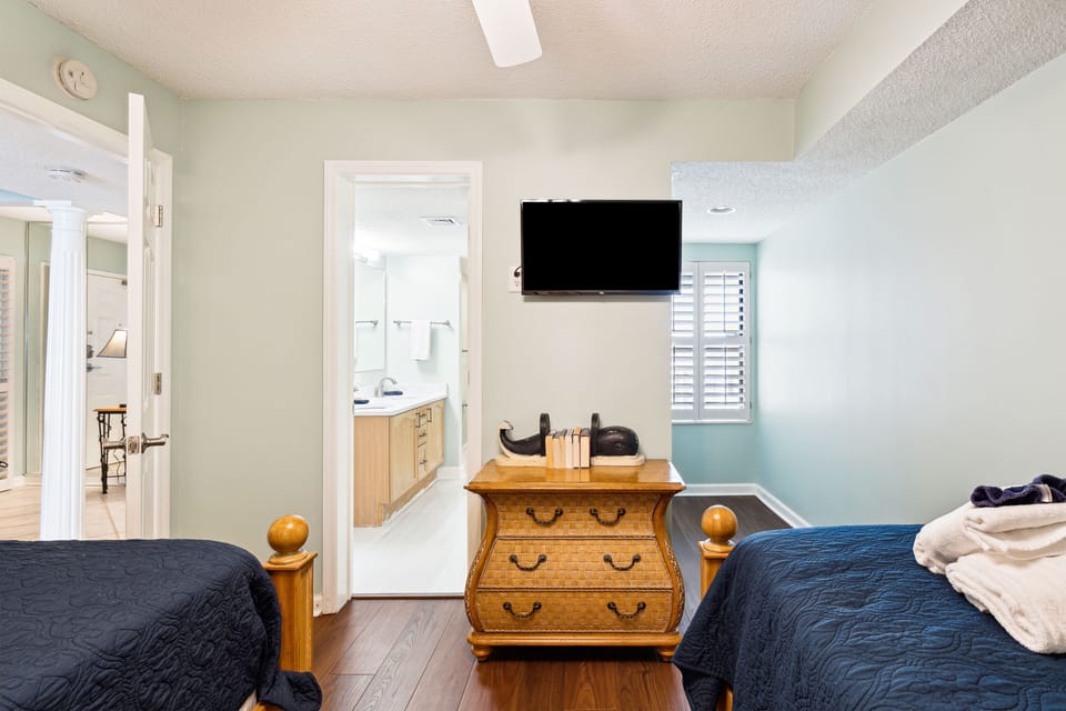 Smart tv in the twin guest bedroom with shared guest bath access.