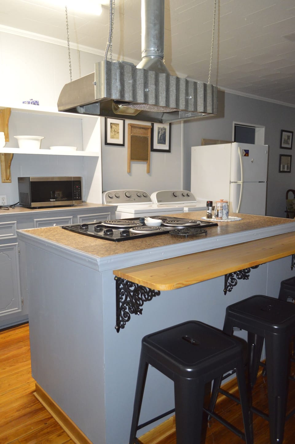 Counter top with stove and bar stools for eating.